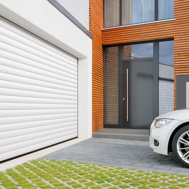 Weißes Auto vor Garage mit Rolltor