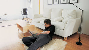 Mann mit Laptop am Wohnzimmerboden
