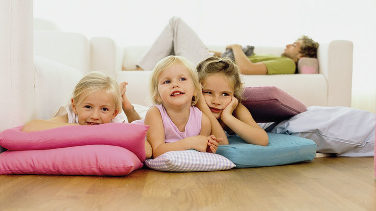 Drei auf Kissen liegende Kinder am Fussboden