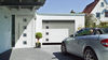 Silbernes Auto vor weißer Garage mit Sectionaltor
