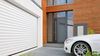 Weißes Auto vor Garage mit Rolltor