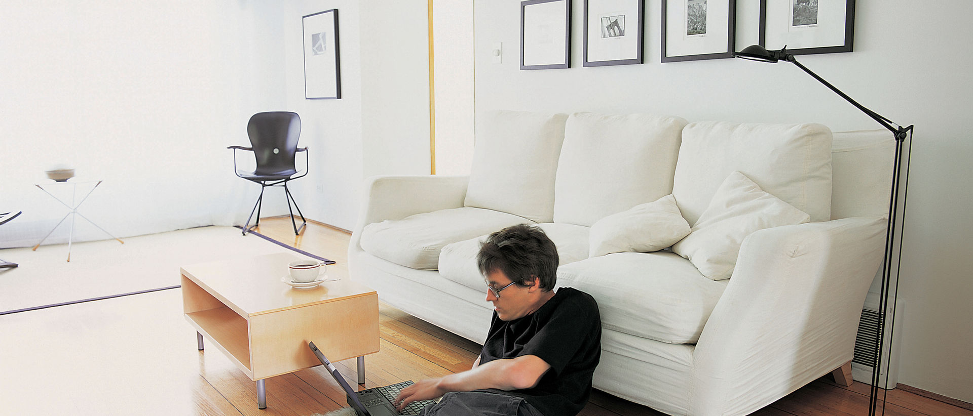 Mann mit Laptop am Wohnzimmerboden