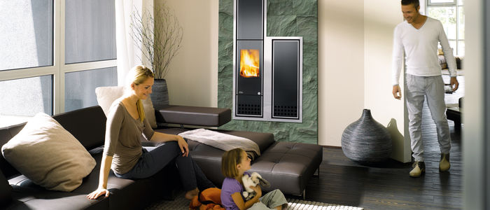 Froehliche Familie im Wohnzimmer vor dem Kamin