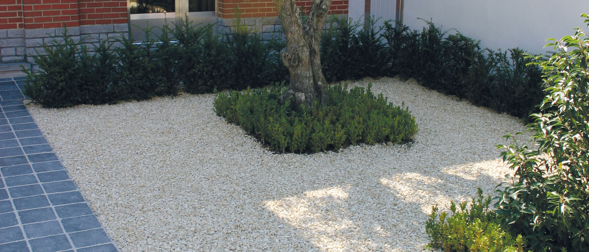 Hofbereich aus Kies mit Baum