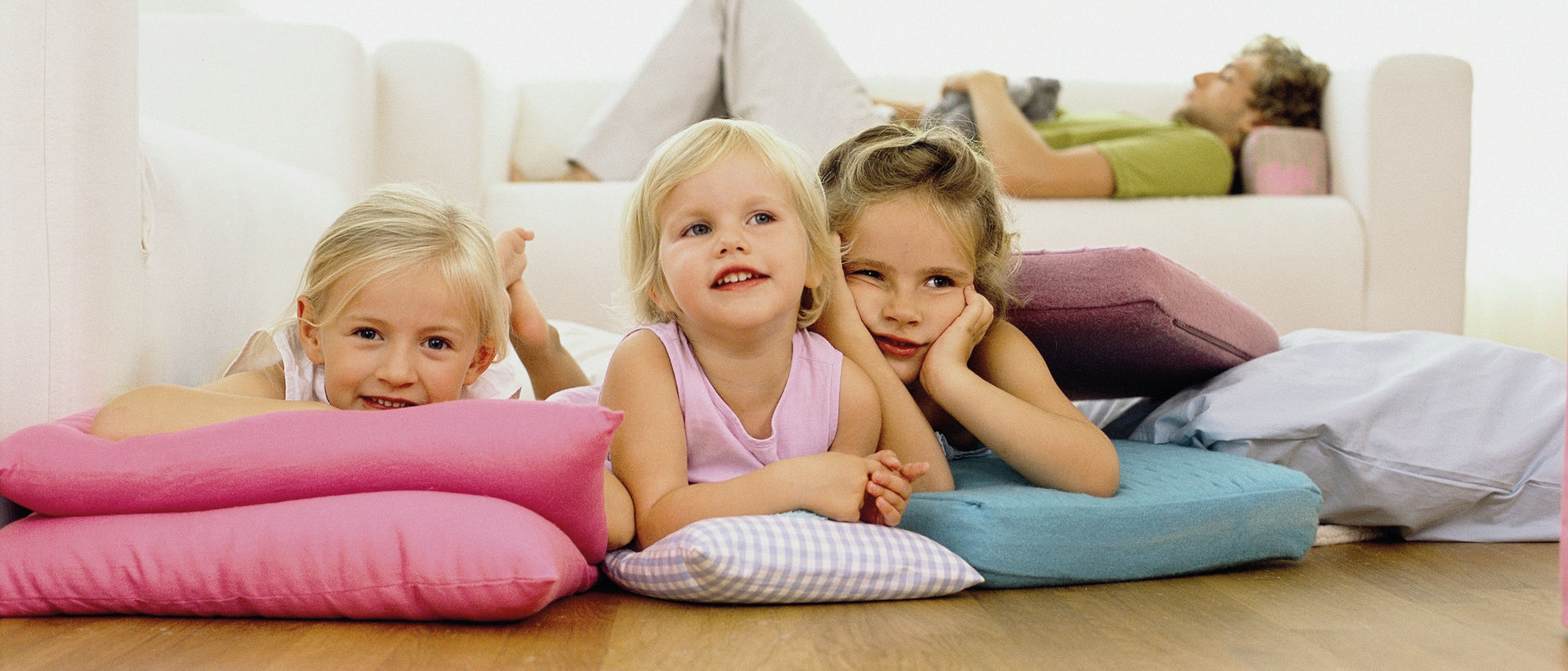 Drei auf Kissen liegende Kinder am Fussboden