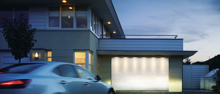 Auto vor Haus und Garage bei Abenddaemmerung